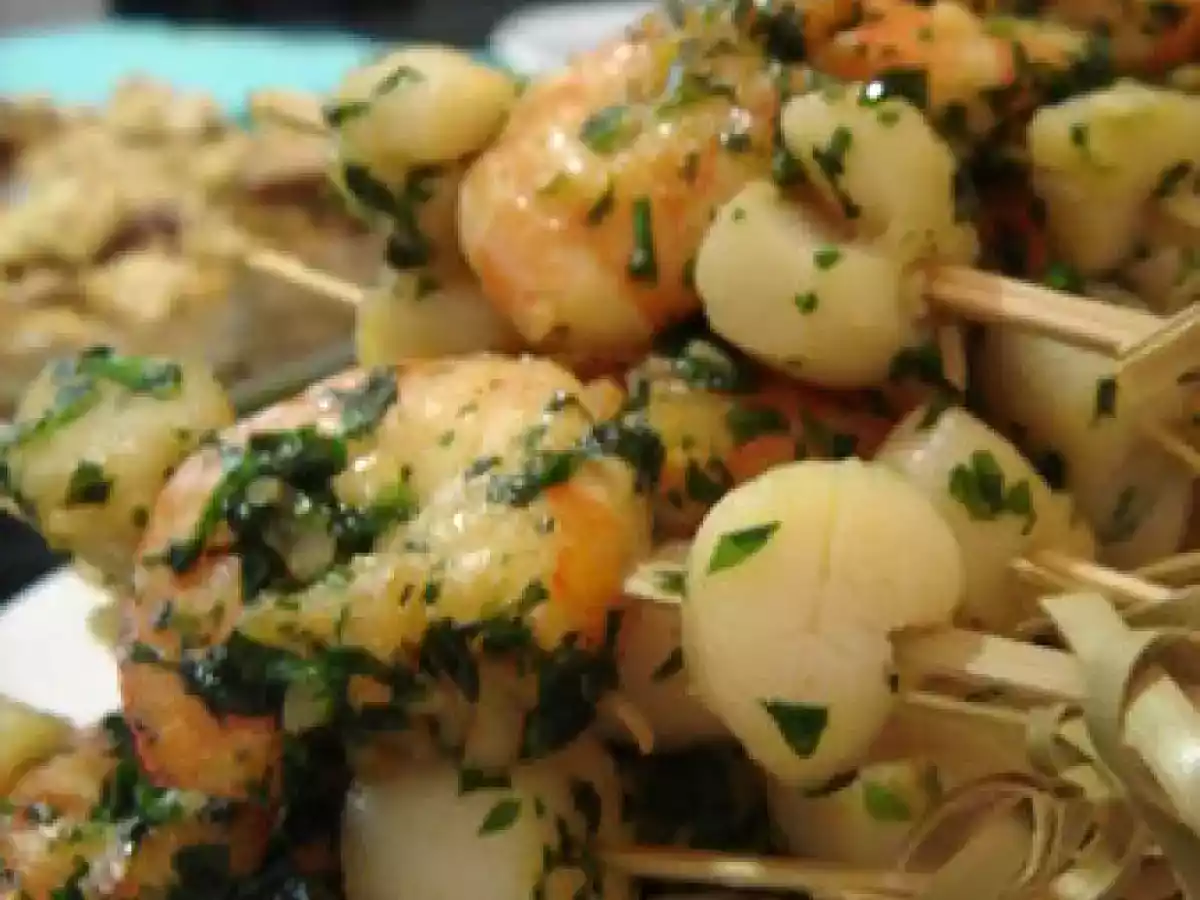 Brochettes de gambas et noix de saint jacques sur lit d'herbes fraîches